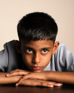Portrait of young woman sitting against white background