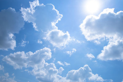 Low angle view of sunlight streaming through clouds