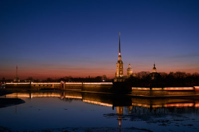 Reflection of building on water at sunset