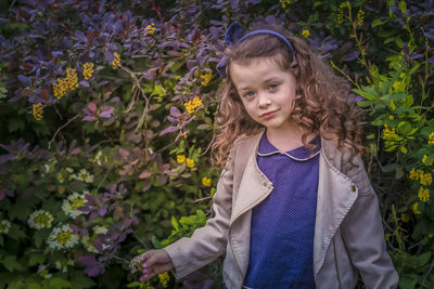 Portrait of girl standing on purple flowering plants