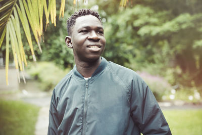 Young african american man in bomber jacket in park. fall or spring season