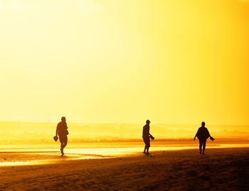 Tourists visiting beach against sky