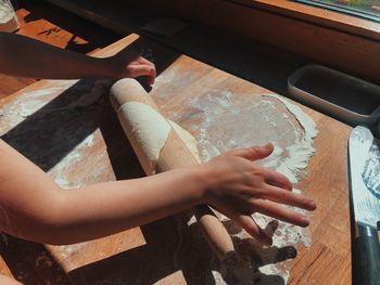 High angle view of girl rolling dough