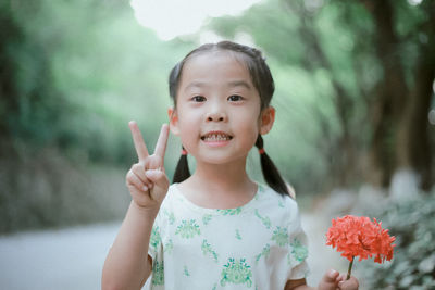 Close-up portrait of cute girl holding flower