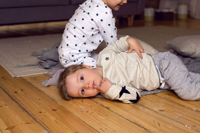 Two brothers in pajamas having fun on new year's eve next to the tree