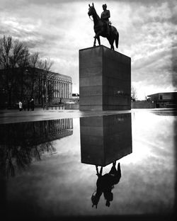 Silhouette man statue against sky in city