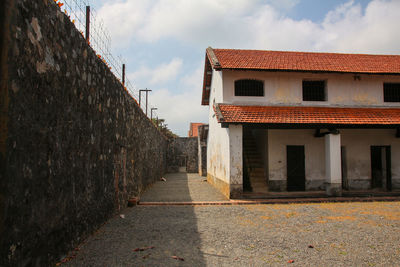 Footpath amidst buildings against sky