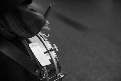Cropped hand playing drum on street