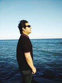 Man standing in sea against clear sky