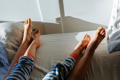 Elder child and smaller child feet in the parent's bed