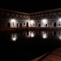 Reflection of illuminated building in canal at night