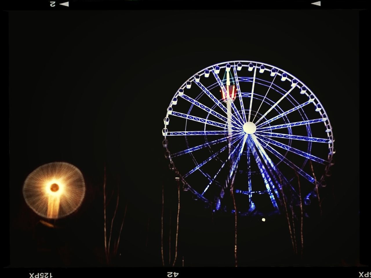 low angle view, illuminated, night, circle, arts culture and entertainment, ferris wheel, amusement park ride, amusement park, glowing, lighting equipment, sky, transfer print, no people, built structure, geometric shape, decoration, outdoors, auto post production filter, clear sky, architecture