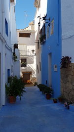 Street amidst buildings against blue sky