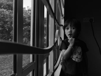 Portrait of cute boy looking through window