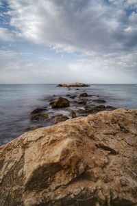 Scenic view of rocks on beach against sky