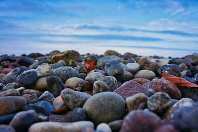 Stones in sea against sky