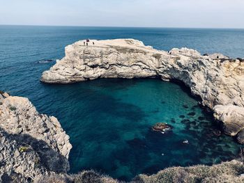 Rock formations in sea against sky