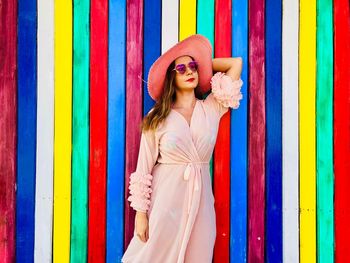 Woman in dress standing against multi colored wall