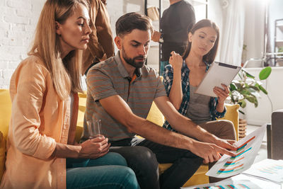 Friends using digital tablet while sitting at home