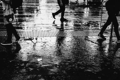 Low section of people walking on wet street during rainy season