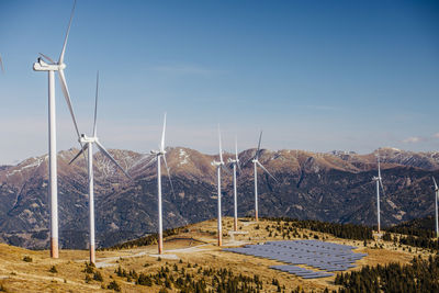 Wind turbines on mountain against sky