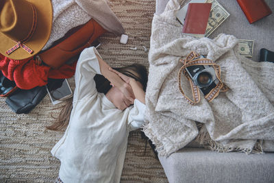 Young woman just arrived in the hotel and relaxing at the floor after a long flight