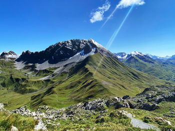 Scenic view of snowcapped mountains against blue sky