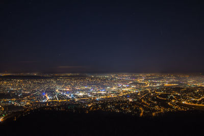 Aerial view of illuminated cityscape against sky at night