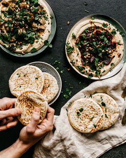 Cropped hands holding bread in kitchen