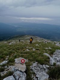 Rear view of people on mountain against sky