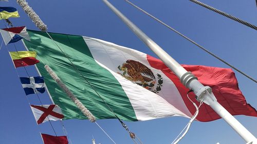 Low angle view of flags hanging against sky