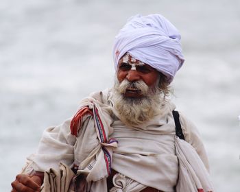 Portrait of man with umbrella against water