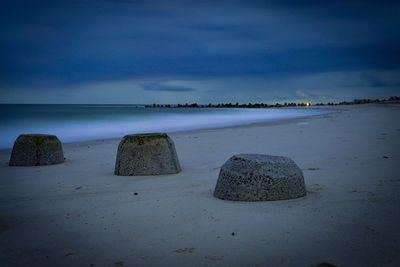 Scenic view of rocks on beach against sky