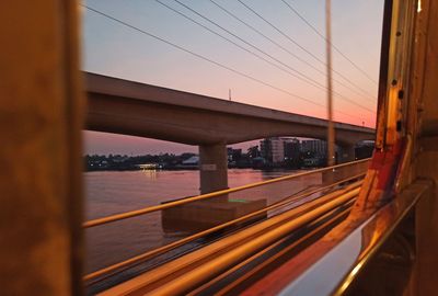 Bridge over river against sky during sunset