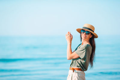 Woman wearing hat against sea against sky