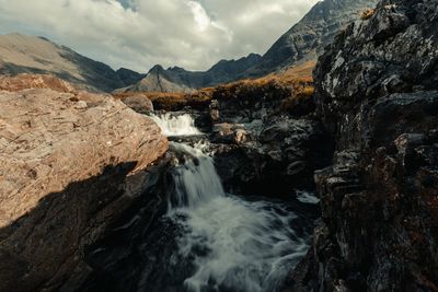 Scenic view of waterfall against sky