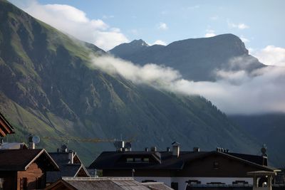 Panoramic view of buildings and mountains against cloudy sky