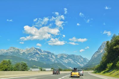 Cars on road against mountain range