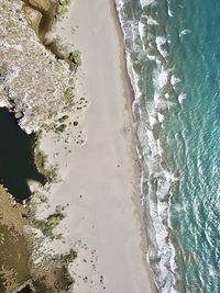 High angle view of waves rushing towards shore