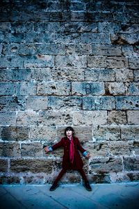 Full length of boy standing against wall