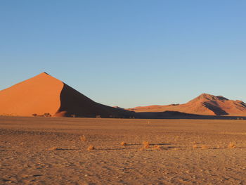 Scenic view of desert against clear blue sky