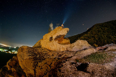 Low angle view of rock formation against sky at night