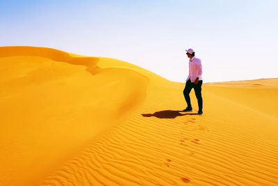Full length of man standing on sand dune