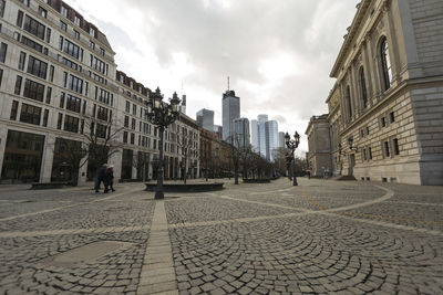 People walking on street against buildings in city