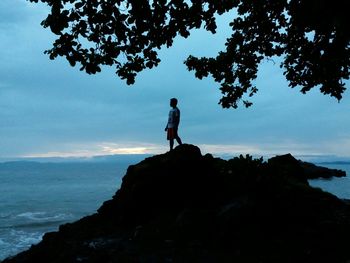 Rear view of woman standing on rock