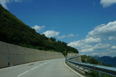 Road amidst trees against sky