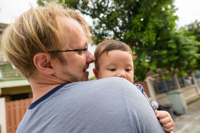 Rear view of man with baby outdoors