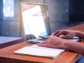 Midsection of man using laptop on table