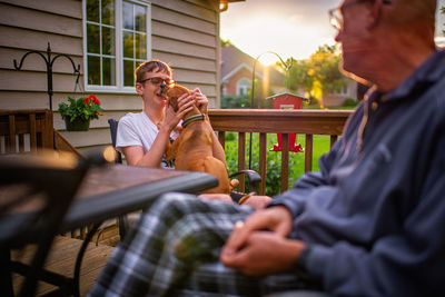 Man and boy with dog sitting at table