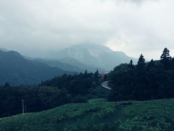 Scenic view of mountain range against cloudy sky